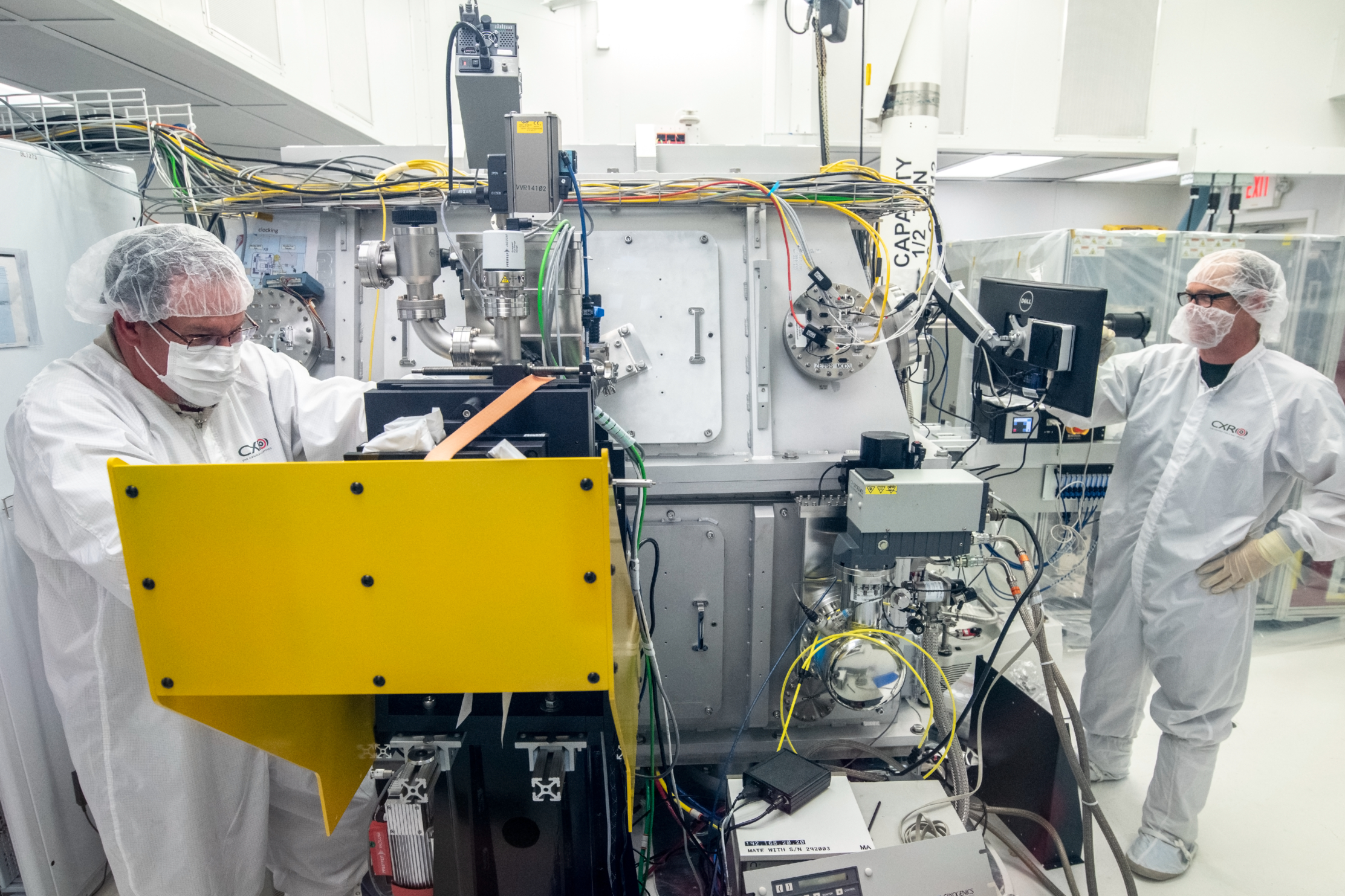 Scientists in protective equipment monitor X-ray Optics Beamline 10.0.1.4 at the ALS