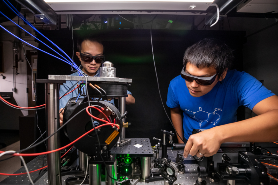 Two scientists prepare a laser